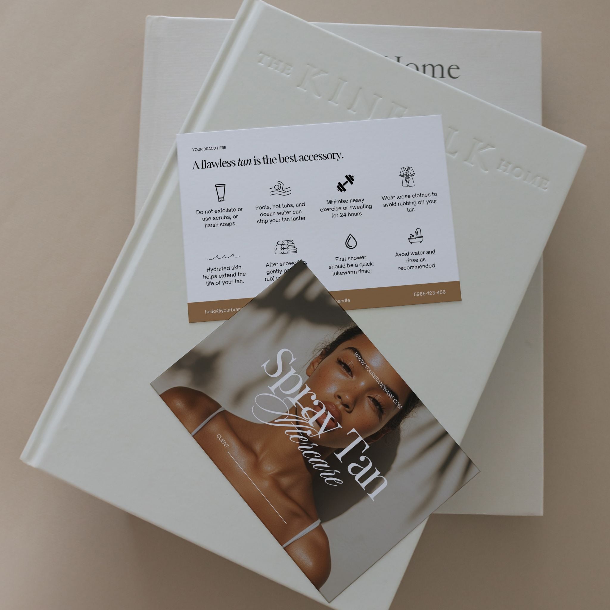 Two books on a beige surface with a flyer about spray tanning on top.